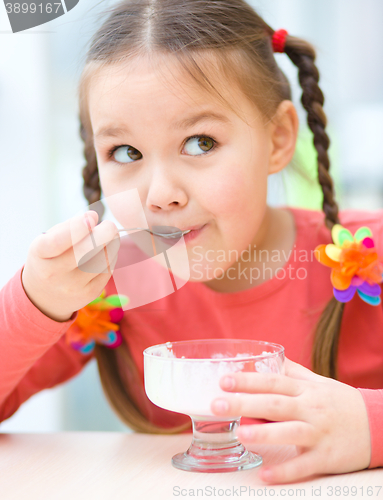 Image of Little girl is eating ice-cream in parlor