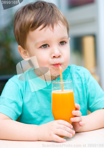 Image of Little boy with glass of orange juice