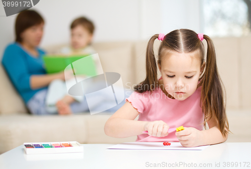 Image of Little girl is playing with plasticine