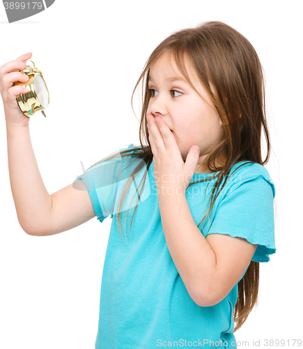 Image of Little girl is looking at alarm clock