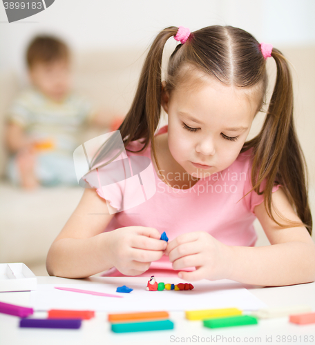 Image of Little girl is playing with plasticine