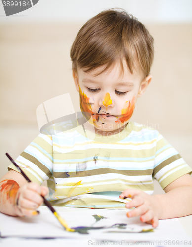 Image of Little boy is playing with paints