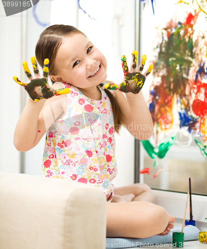 Image of Portrait of a cute girl playing with paints