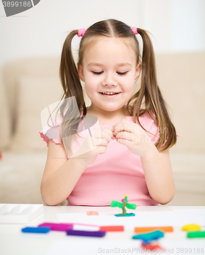 Image of Little girl is playing with plasticine