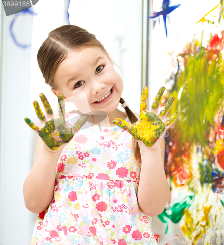 Image of Portrait of a cute girl playing with paints