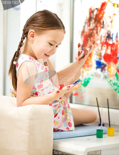 Image of Portrait of a cute girl playing with paints