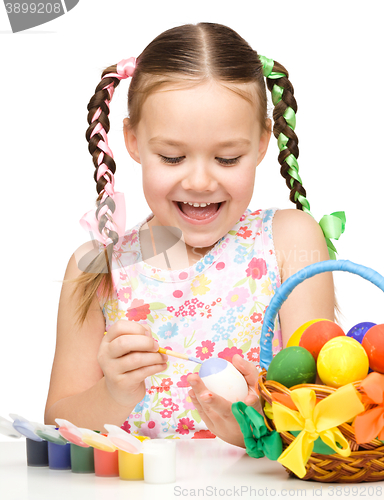 Image of Little girl is painting eggs preparing for Easter