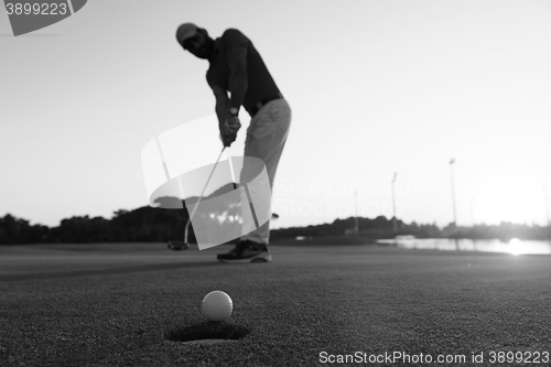 Image of golfer  hitting shot at golf course