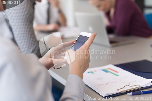 Image of close up of  busineswoman hands  using smart phone on meeting