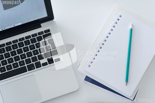 Image of flat lay of laptop and notepad