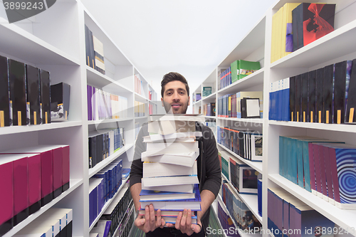 Image of Student holding lot of books in school library