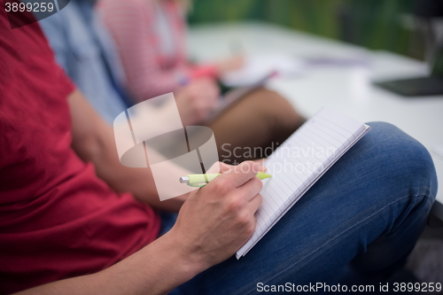 Image of male student taking notes in classroom