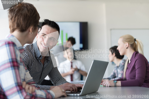 Image of young business couple working on laptop, businesspeople group on