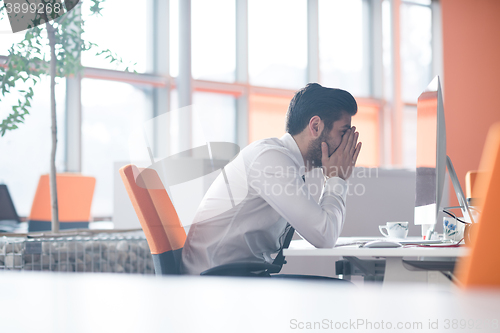 Image of frustrated young business man at work