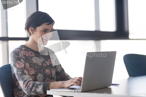 Image of young business woman at office working on laptop with team on me