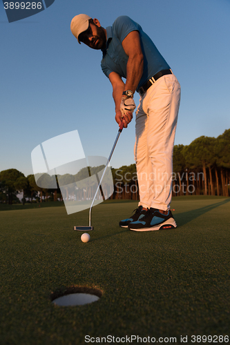 Image of golfer  hitting shot at golf course