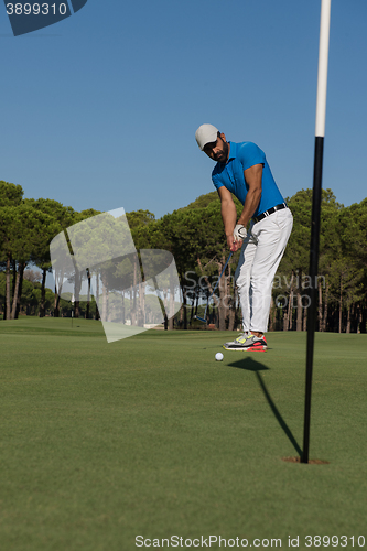 Image of golf player hitting shot at sunny day