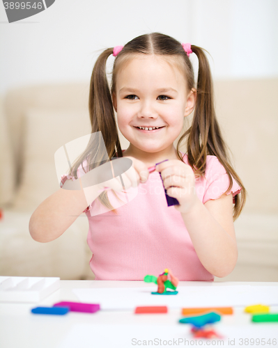 Image of Little girl is playing with plasticine