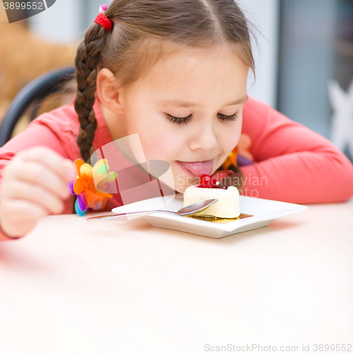 Image of Little girl is eating cake in parlor