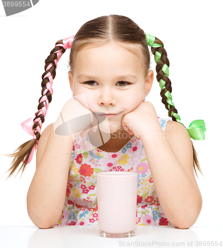 Image of Sad little girl with a glass of milk