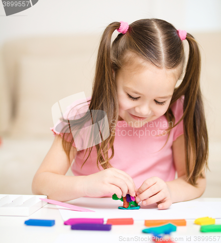 Image of Little girl is playing with plasticine