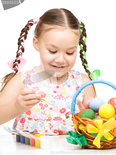 Image of Little girl is painting eggs preparing for Easter