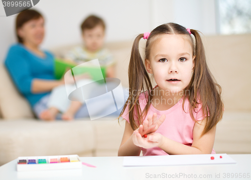 Image of Little girl is playing with plasticine