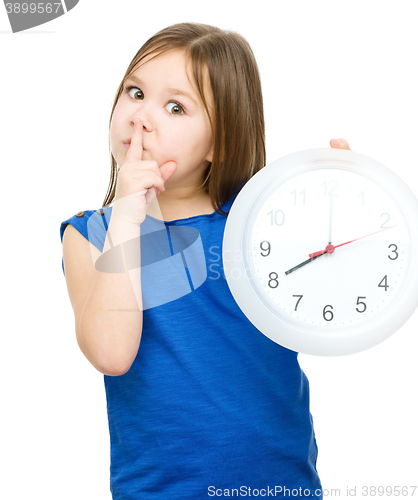 Image of Little girl is holding big clock