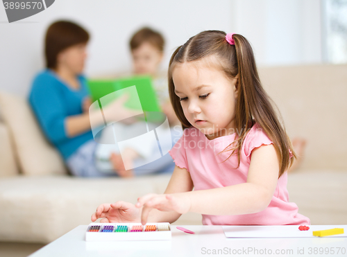 Image of Little girl is playing with plasticine