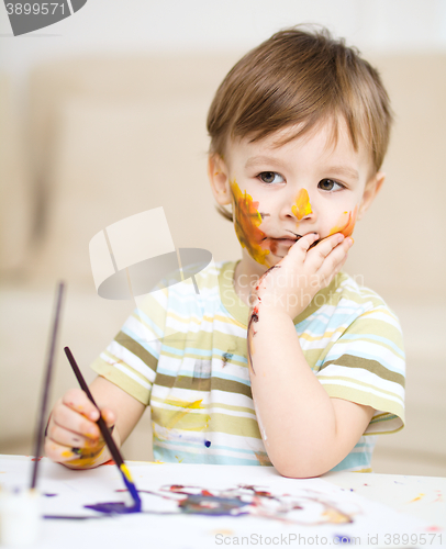 Image of Little boy is playing with paints