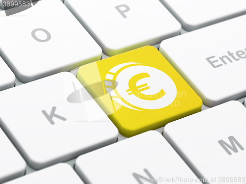 Image of Currency concept: Euro Coin on computer keyboard background