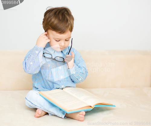 Image of Little boy is reading book