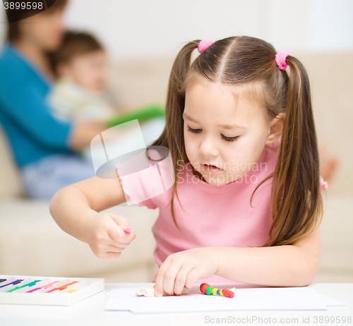 Image of Little girl is playing with plasticine