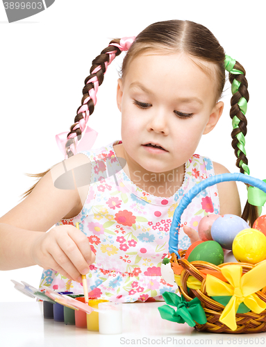 Image of Little girl is painting eggs preparing for Easter