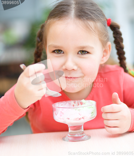 Image of Little girl is eating ice-cream in parlor