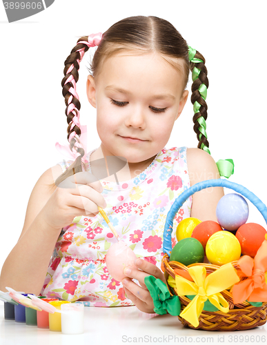 Image of Little girl is painting eggs preparing for Easter