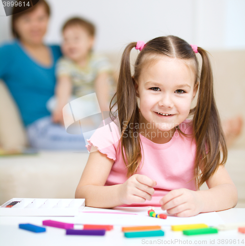 Image of Little girl is playing with plasticine