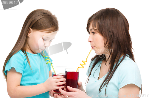 Image of Mother and her daughter are drinking juice