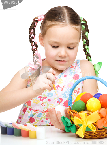 Image of Little girl is painting eggs preparing for Easter