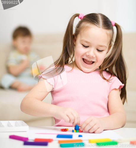 Image of Little girl is playing with plasticine