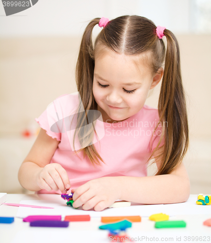 Image of Little girl is playing with plasticine