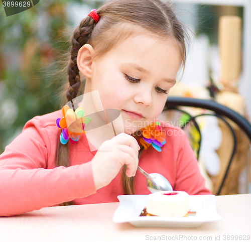 Image of Little girl is eating cake in parlor