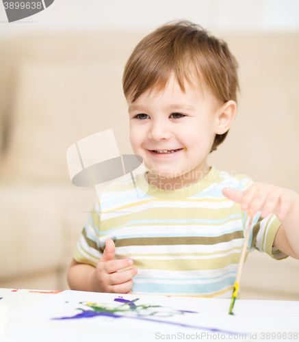 Image of Little boy is playing with paints