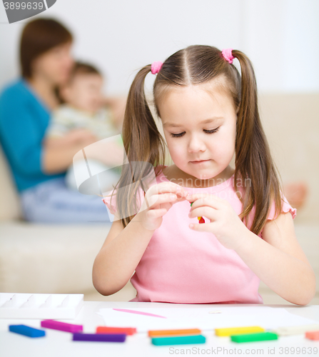 Image of Little girl is playing with plasticine