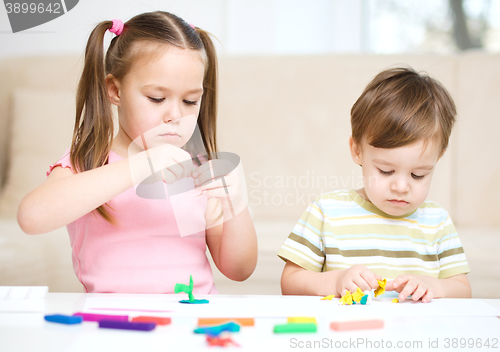 Image of Sister and brother are playing with plasticine