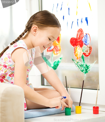 Image of Portrait of a cute girl playing with paints