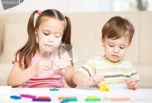 Image of Sister and brother are playing with plasticine