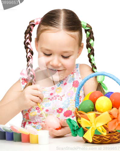 Image of Little girl is painting eggs preparing for Easter