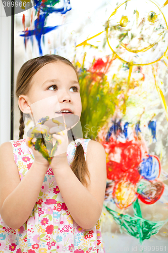 Image of Portrait of a cute girl playing with paints