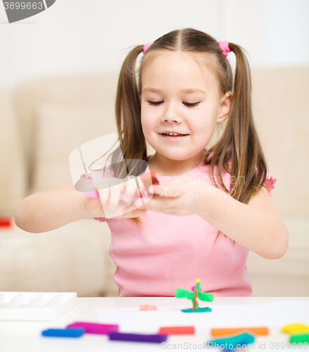 Image of Little girl is playing with plasticine